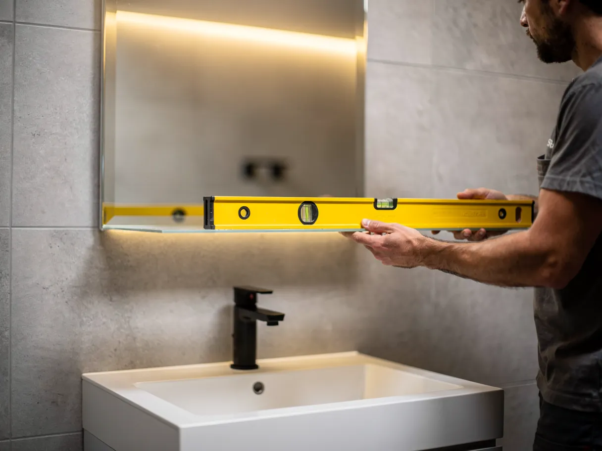 Pose d'un miroir sur mesure dans une salle de bain
